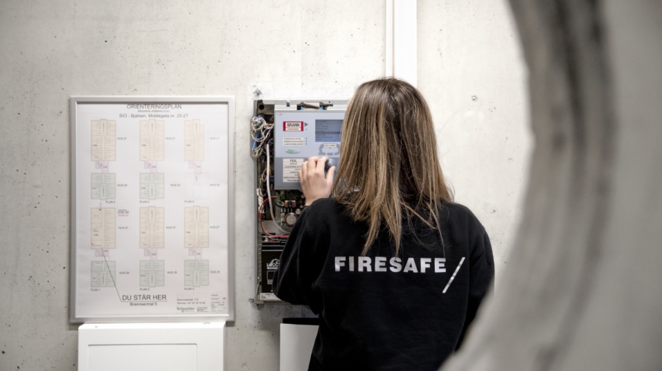 Medarbeider kontrollerer en brannsentral